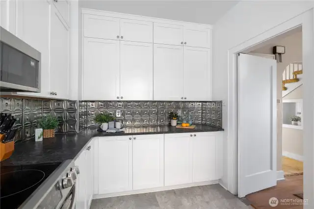 Kitchen flows to back hall with pantry