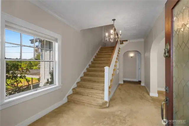 Elegant entry way with crystal chandelier and wide staircase