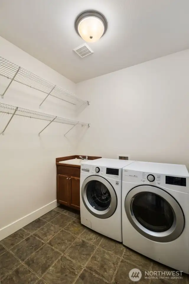 Main level massive laundry room. Huge potential for added storage in here or doggie wash area, etc.  This is a perfect mud room area off of the garage.