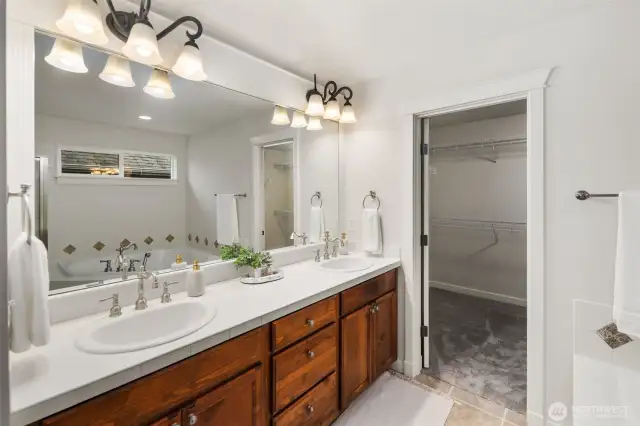 Cared for primary bathroom with tiled shower, soaking tub, separate toilet area and large walk in closet and linen closet.