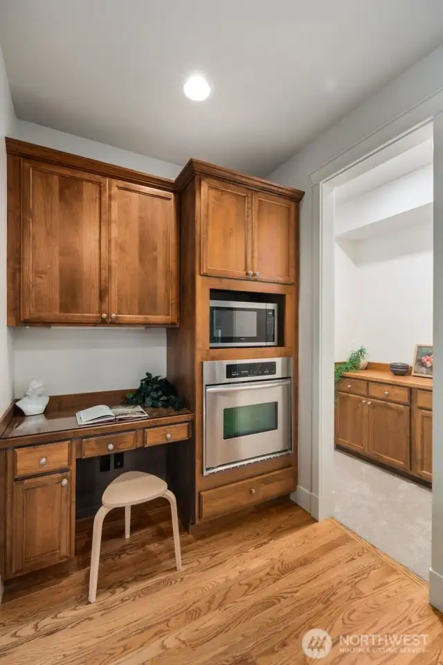 Butler pantry in the background with additional storage. Coffee bar? Wine bar?    Intentional work from home space in the kitchen area. Owner put in a microwave for their own use, but this space also accommodates a convection microwave oven.