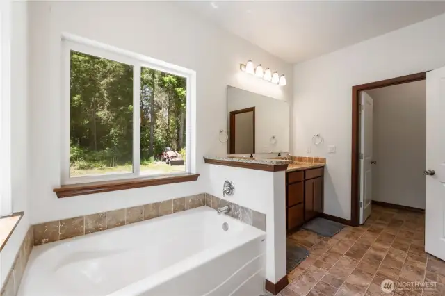 Primary bath also offers a soaking tub and walk-in shower through the door.