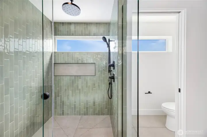 Primary shower with heated floors and rain shower head.