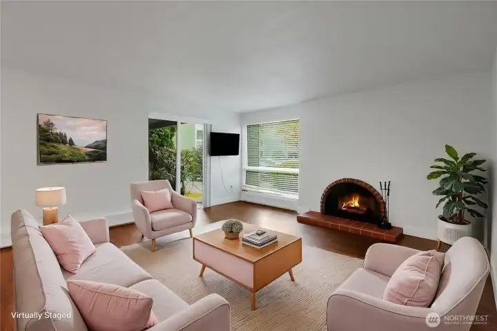 Bright and spacious living room with access to your patio and a cozy fireplace. (virtually staged)