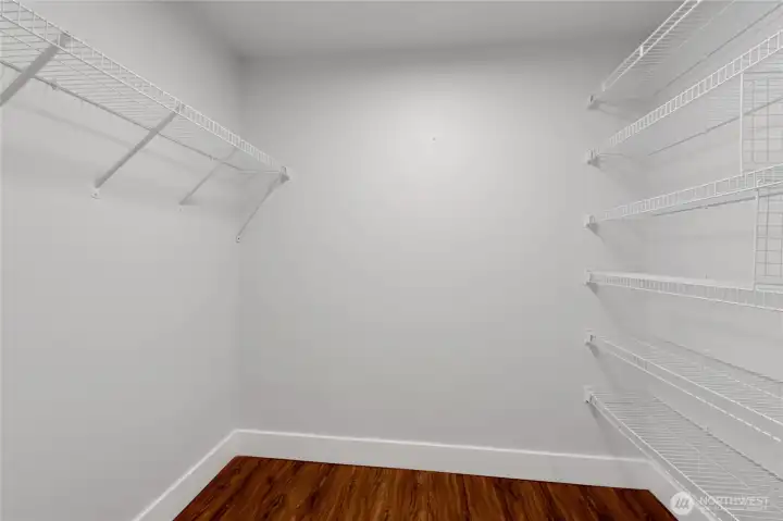 Walk-in closet with wire hanging rack and shelving already installed.