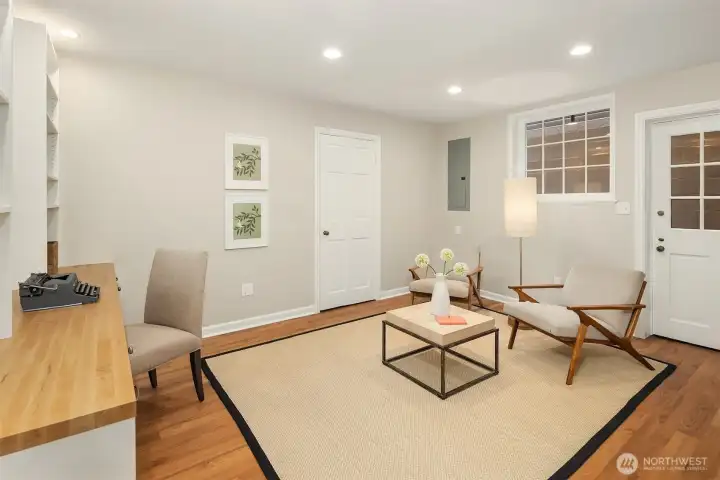 A spacious lower-level retreat, complete with a private entrance and built-in desk area flanked by bookshelves, provides the perfect environment for productivity and privacy.
