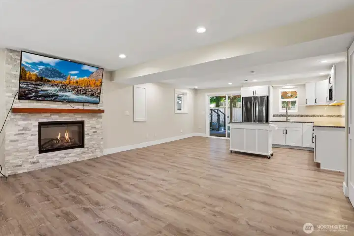 Generously sized 'rec room' with fireplace (the panel on the wall is hiding the electrical panel; water heater & furnace in the closet to the right) Generously sized 'rec room' with fireplace (the panel on the wall is hiding the electrical panel; water heater & furnace in the closet to the right)