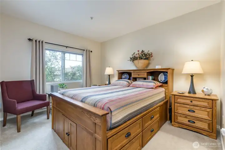 Retreat to your primary bedroom suite, offering a serene, private view of mature trees.