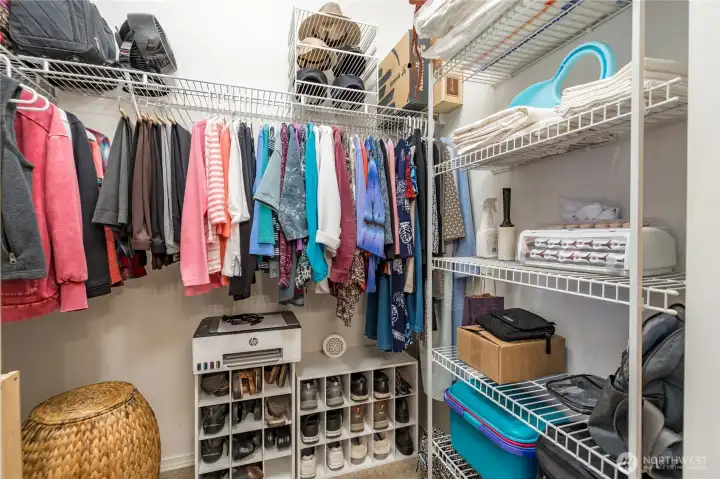 Generously sized primary walk-in closet complete with a built-in organization system.