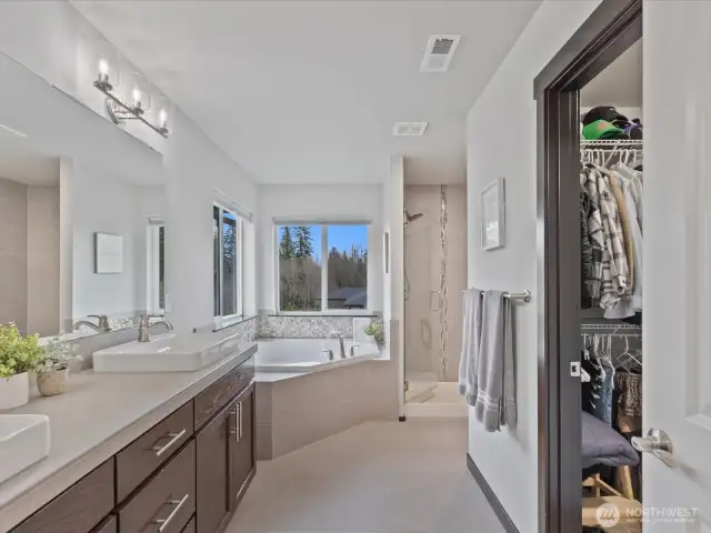 A true sanctuary! This luxurious primary suite features a spacious layout, serene views, and a spa-like ensuite with a soaking tub, dual vanities, and a walk-in shower.