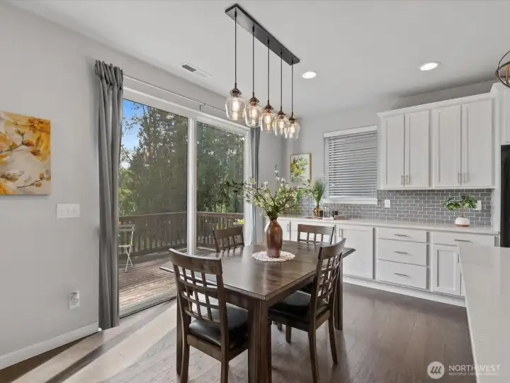 Dining space features trendy pendant lighting and slider to deck.