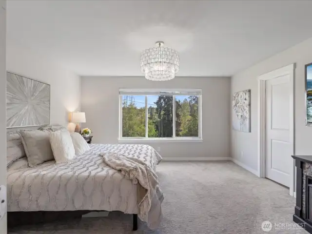 Primary Suite with large picture windows and stunning chandelier lighting.