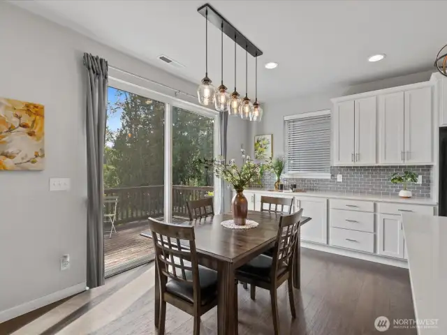 Dining space features trendy pendant lighting and slider to deck.