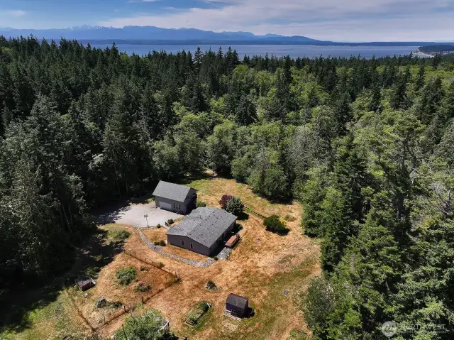 Sunny private level acreage with fenced garden space and walking trails through your woods. Short-term or long-term rental income potential with the guest space above the detached garage/shop.
