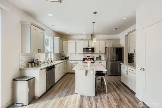 Beautiful and bright kitchen with gorgeous granite counters, stainless steel appliances, and tons of storage. The space is well-designed and functional, making it a heart of the home for cooking and entertaining.