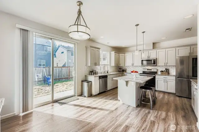 The kitchen features a large slider that opens directly onto the patio, seamlessly extending the living space and perfect for entertaining and gatherings. The property boasts a fully fenced backyard, providing a safe and private outdoor area for enjoyment.