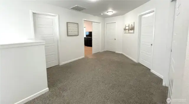 Upon ascending the staircase, you are greeted by a generously sized landing area which serves as the central hub, offering convenient and easy access to all of the spacious bedrooms. French doors to the left lead to the private Primary Suite.