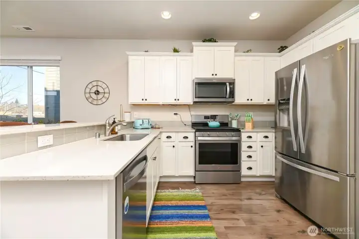 White cabinetry, stainless steel appliances and quarts counter tops.