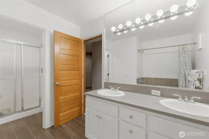 Upstairs full bath has double sinks, bath, and separate shower/toilet area.