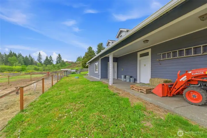 Backside of garage has entrance to bar area, man door to rv area, rv cleanout and covered area for storage.