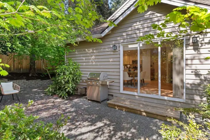 Tranquil patio is surrounded by mature, low maintenance greenery.