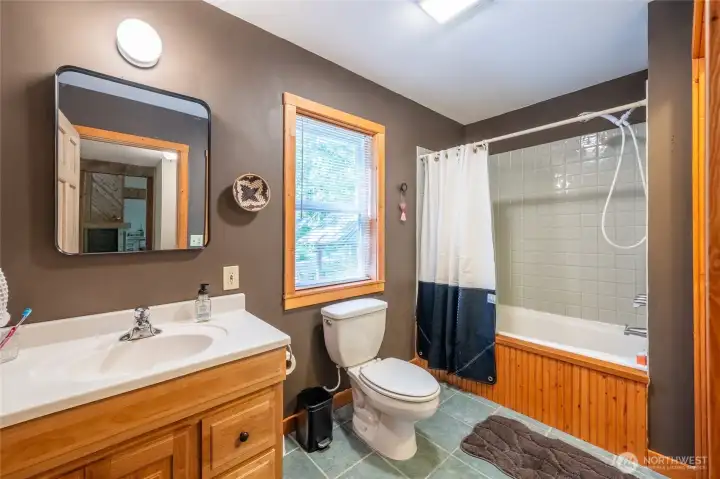 The main floor bathroom is accessible from the hallway and the primary bedroom.