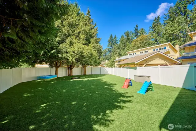 The outdoor play area has turf and offers a safe play space within the community.