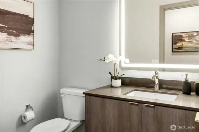 Tucked behind a modern barn door is an alcove with a convenient half bathroom on the main living level. There is also a large pantry/storage closet in this alcove.