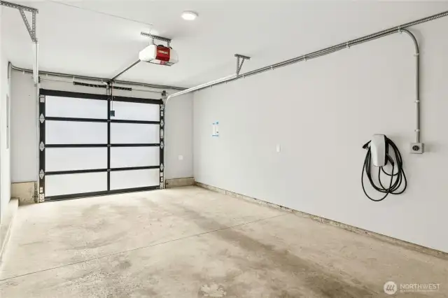The wonderfully convenient connected tandem 2-car garage in this home has a Tesla EV-charger and extra storage space too.