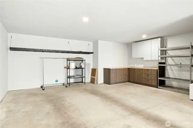 The over-sized 852 sf garage with built-in cabinetry storage and shelving.