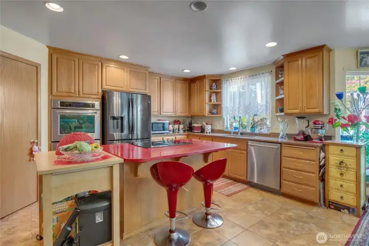 Chef-Inspired Kitchen – Featuring a large island with gas cooktop, stainless steel appliances, double oven, and abundant cabinetry.
