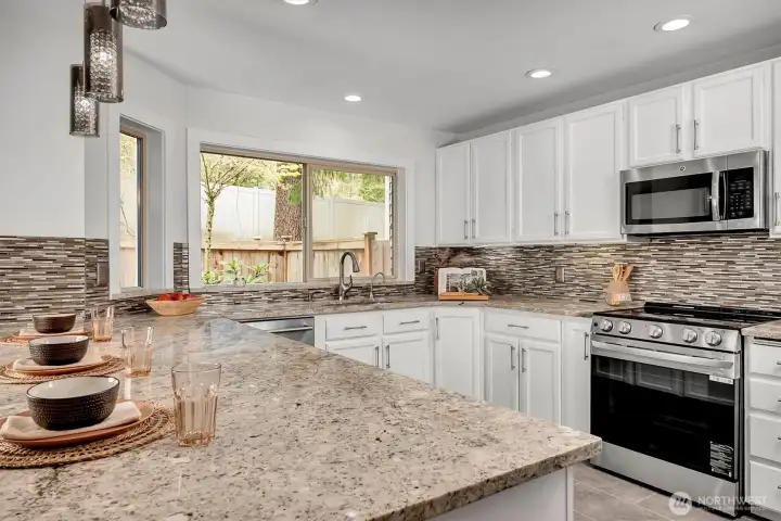 Light, bright w/windows filled with green. Beautiful tile touches, quartz countertops, SS appliance and cabinets galore. This kitchen is a Chef's dream!