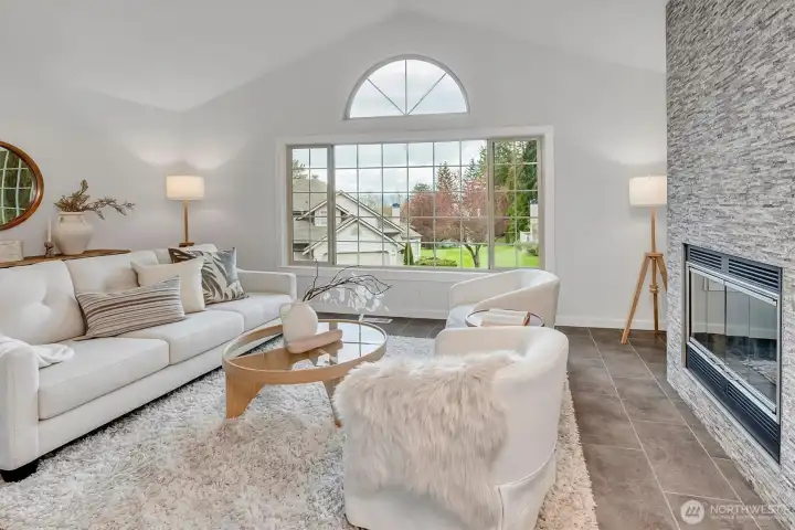 5 steps from the main floor is this stunning living room w/custom tile floors and fireplace. This space is filled with light, and is beyond generous in size. You will LOVE the vaulted ceilings, floor to ceiling custom fireplace and on those clear PNW days....the VIEWS of the Cascade mountain range will make you smile! Serene + peaceful....a true treasure is this home in Walnut Hills of Redmond.