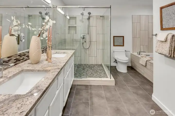 The primary en'suite bath remodel includes....double vanity w/custom tile floors, backspace, shower floor and quartz counter tops. Glorious custom shower + jetted tub. This bathroom feels like your own private + perfect spa!