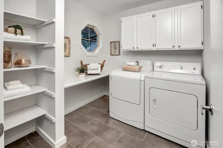 Full size laundry room, not a small closet, features tile floors, lots of storage and great appliances too!