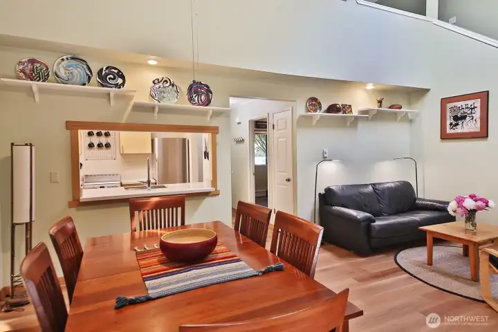 Your back is to the French Doors. Vaulted ceilings creates an expansive openness. There is a ceiling fan above the dining area.