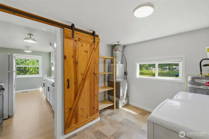 Beautiful utility room full of storage with a well crafted wooden barndoor. Beautiful utility room full of storage with a well crafted wooden barndoor.
