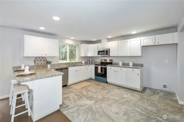 A very spacious kitchen with lots of counter space and cabinets make cooking a breeze. All new stove and microwave. Ceramic tile floor and granite counters.