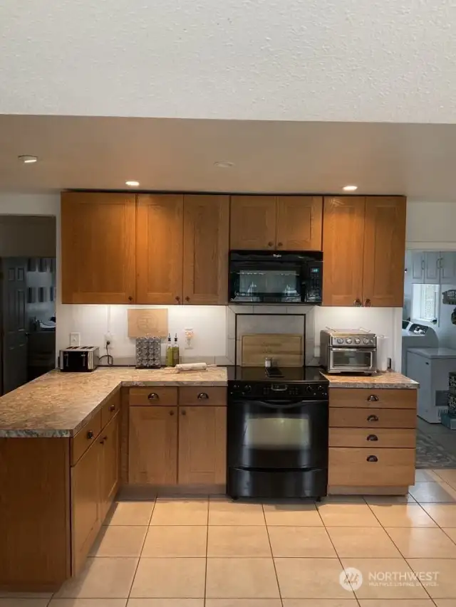 Kitchen. Tile floors and nice wood cabinets.