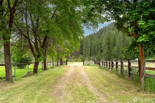 A tree-lined entry leads to the secluded property within easy access from Poorman Creek Road.