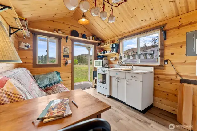 The tiny cabin features lots of windows, a covered porch, knotty pine interior and 1/2 bath.