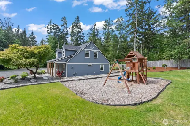 Beautiful updated farmhouse-style home with charming curb appeal, wide front porch, and mature landscaping. Adjacent play area with swings and slide offers the perfect setup for kids. Tucked away in a quiet, forested setting, this home boasts privacy, outdoor recreation, and a welcoming layout—ideal for family living in the Pacific Northwest.