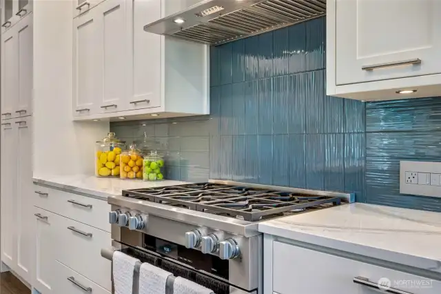 Miele 6-burner dual fuel stove, oven with steam function and Kobe hood fan. Pantry with pull out shelves at far left.