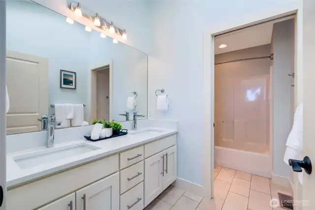 The second floor full bath has amazing natural light from the skylight above.  Travertine floors and quartz countertops.  A separate room for the toilet and shower allow for mulitple people to use the bathroom at once, keeping bathroom squabbles to a minimum.