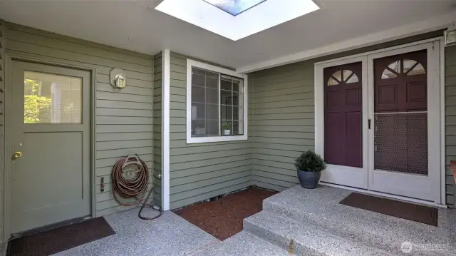 The outside entry area has a covered roof and skylight.
