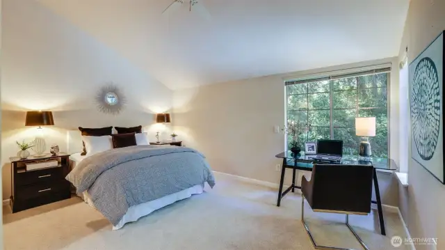 The primary suite has a perfect size and offers a vaulted ceiling and ceiling fan.  The windows give a serene view into the backyard.
