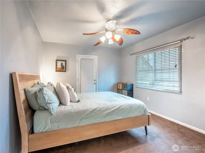 Primary bedroom with preserved original hardwood floors under carpet