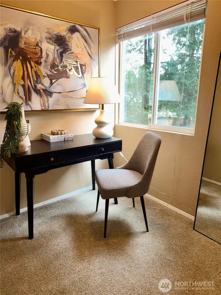 The den is filled with natural light from a large window, making it ideal for working, crafting, or hosting overnight guests.