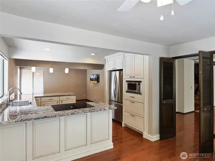 Remodeled chef’s kitchen featuring elegant granite countertops, stainless steel appliances, and custom cabinetry that perfectly complements the rich hardwood floors
