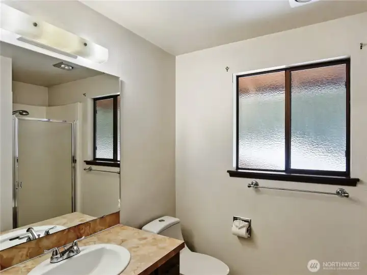 The hall bathroom is thoughtfully designed with a clean shower to accommodate both daily family life and visiting guests.